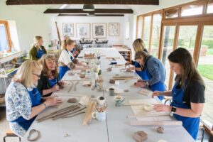 A group round the table making things with clay